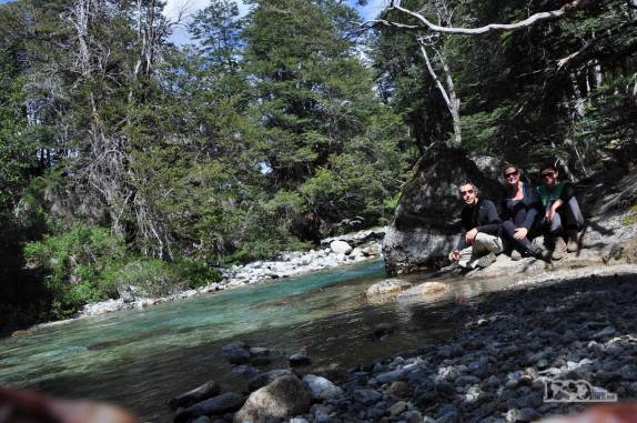 Descanso e lanche ao lado do rio na trilha de volta do Refúgio San Martín, no lago Jakob, na região de Bariloche, na Argentina